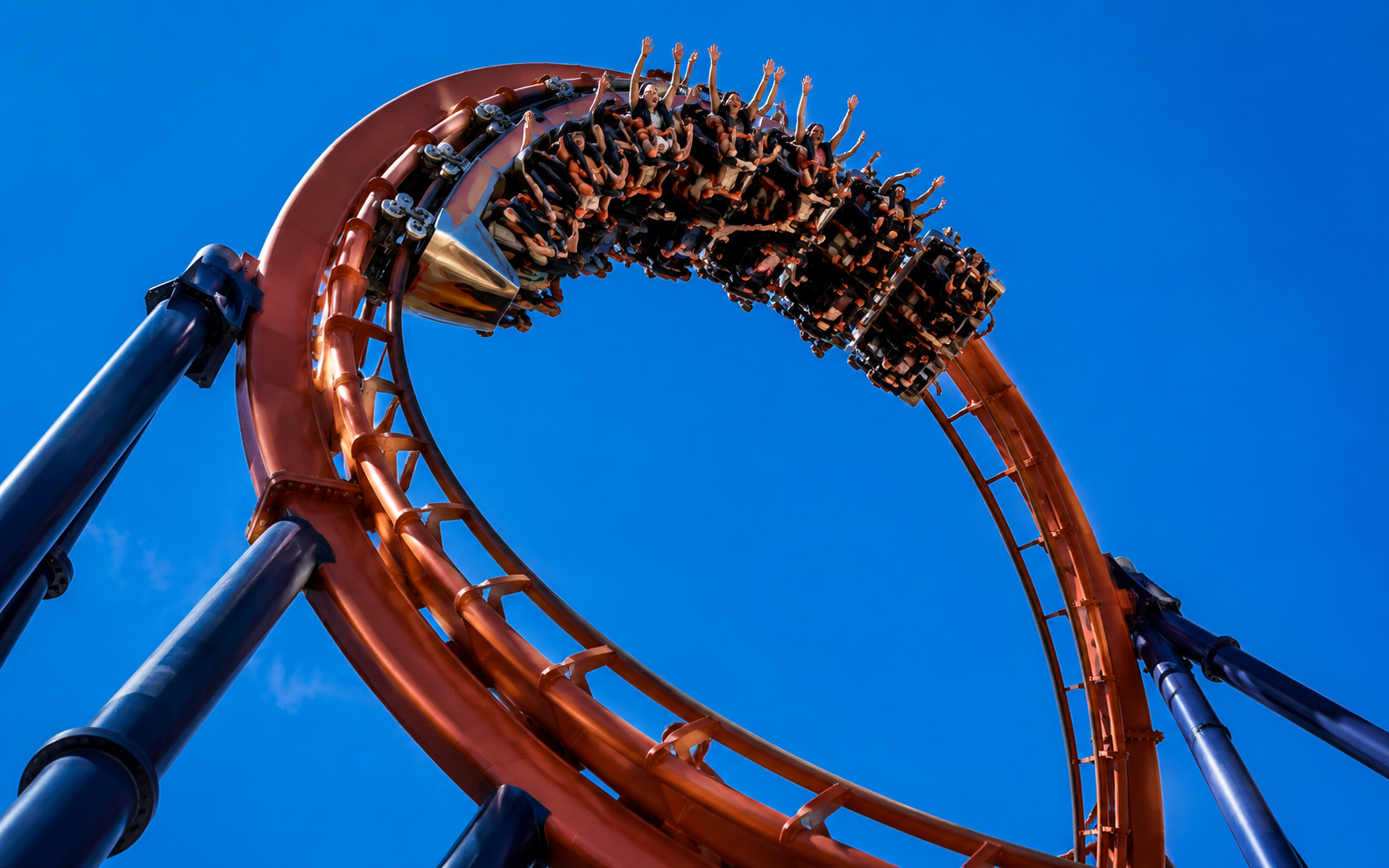 A roller coaster loop against a blue sky